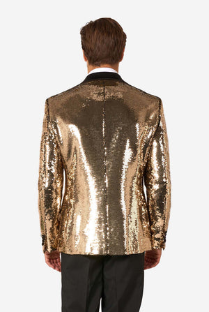 Rear view of a man wearing a shiny gold sequin blazer with black lapels and black trousers.