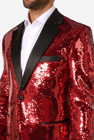 Close-up of the chest area of the red sequin blazer, highlighting the black lapel and pocket trim.