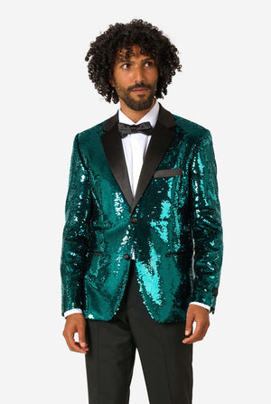 Man wearing a teal sequin blazer with black satin lapel, white dress shirt, and black bow tie, standing and looking slightly to the side.