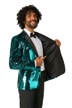 Man smiling and pointing at the inside of his open teal sequin blazer, showing black satin lining with OppoSuits branding.