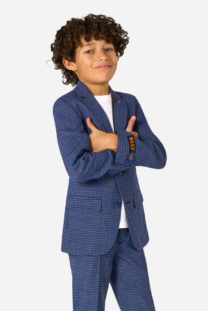 A boy wearing a navy and blue checkered suit with a white dress shirt. The suit has a modern fit with two buttons and flap pockets. He stands against a plain white background.