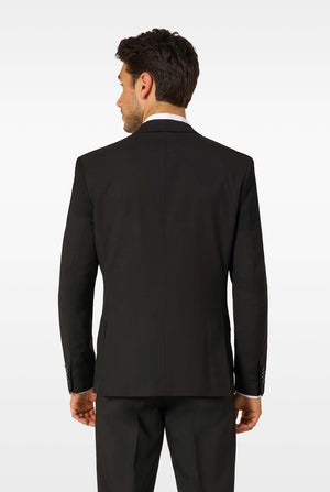 Back view of a man wearing a black blazer and black trousers, showing the tailored fit and seams.