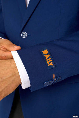 Close-up of the sleeve of a blue blazer with a blue and orange “DAILY” label above button details.