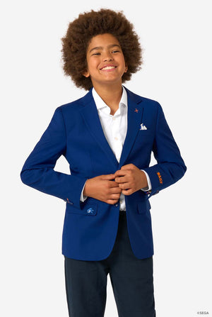 A child smiling while wearing a bright blue blazer, white shirt, and dark trousers, buttoning the jacket.