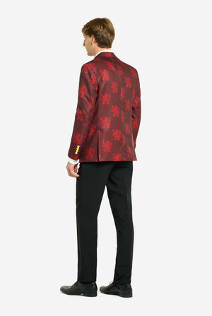 Image with light grey background and man wearing Harry Potter suit, Gryffindor styled. Suit consists of red blazer with Gryffindor logo and light red lions all over print, black pants, and red and yellow diagonal striped tie. Man showing back of the suit.