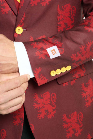 Image with light grey background and man wearing Harry Potter suit, Gryffindor styled. Suit consists of red blazer with Gryffindor logo and light red lions all over print, black pants, and red and yellow diagonal striped tie. Sleeve close up.