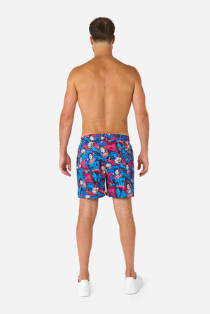 Man wearing a Men's Superman-themed swim shorts featuring a bold comic book design with multiple action poses of the Man of Steel. Perfect for superhero fans looking to make a splash. View from the back.