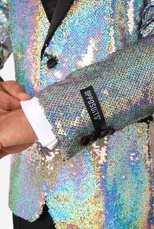 Close-up of holographic silver sequin tuxedo jacket sleeve with black buttons, showing a black OppoSuits brand label above the cuff.