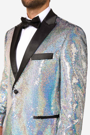 Close-up of upper body in holographic silver sequin tuxedo jacket with black satin lapels, white shirt, and black bow tie.