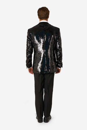 Back view of man wearing a black sequin tuxedo with satin lapels and matching black trousers.