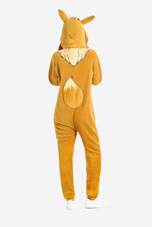 A woman is wearing an adorable Eevee onesie, modeled after the beloved Pokémon character. This adult unisex onesie is designed in a warm brown color, resembling Eevee’s fur, and features a fluffy beige collar mimicking Eevee’s mane. The hood includes Eevee's signature large brown ears. Perfect for Pokémon fans, this cozy fleece onesie is ideal for lounging, cosplay, or themed. View from the back.