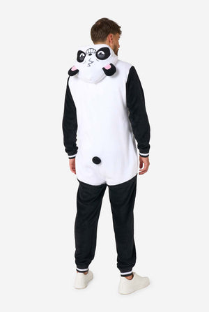 A smiling man wearing a panda-themed adult onesie. This cozy onesie features black and white panda colors with a playful hood showcasing panda ears and a cute face. Perfect for lounging or fun costume occasions. Full body image from the back, with the hood down.