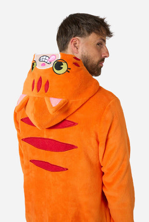 A smiling man is wearing an orange adult onesie designed as a red cat onesie. The onesie features a hood resembling a cat's head, and cat details, perfect for cozy lounging or costume parties. Close up upper body from the back.
