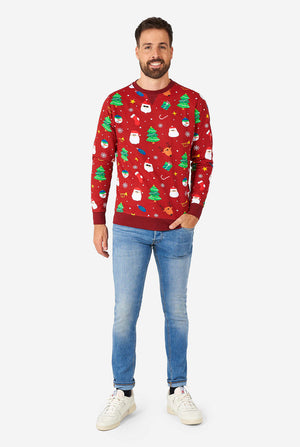 Man wearing red Christmas sweater with colored Christmas icons and blue washed jeans