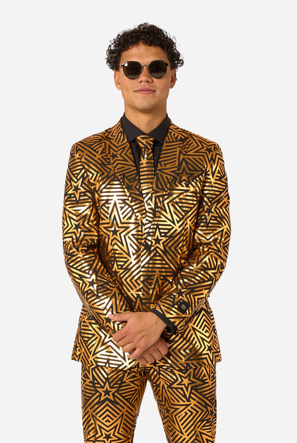 Man wearing a gold and black patterned suit and sunglasses on a white background
