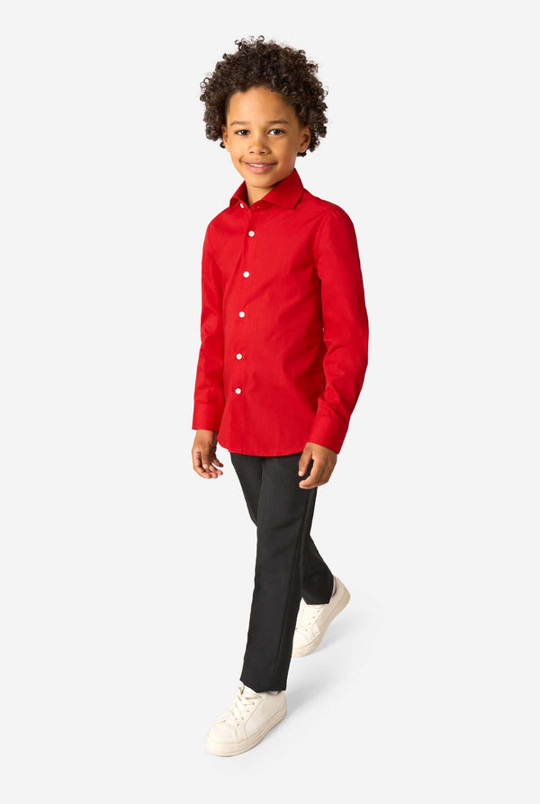 Little kid is wearing a red shirt and black pants. Full body image.