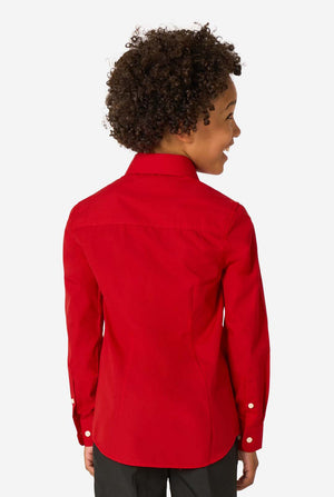 Little kid is wearing a red shirt and black pants. View from the back.