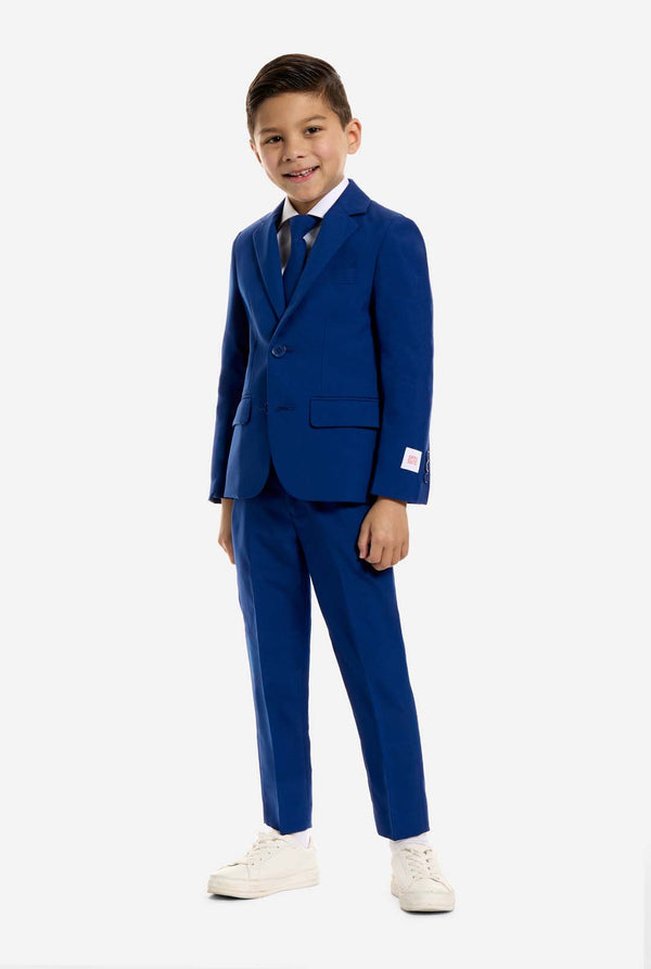 Young boy wearing a blue suit with a white background, full body image