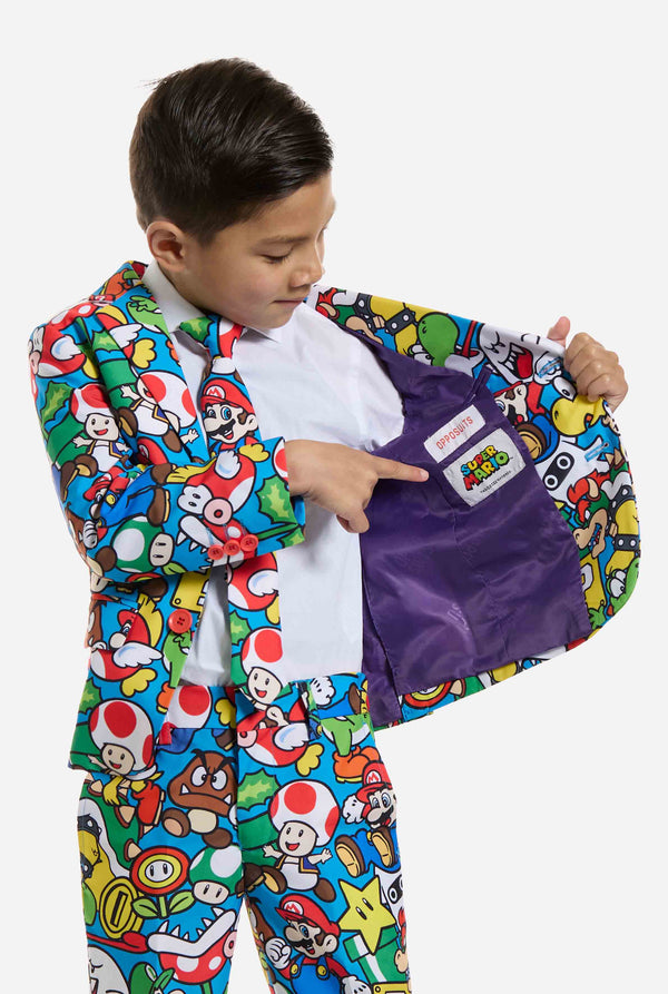 Image of kid wearing a Super Mario all over print suit, consisting of blazer, pants and tie. Main color is blue, but there is also yellow, red and white. Showing inside of the blazer.