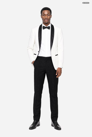 A man modeling a white tuxedo jacket with black satin lapels, paired with a white tuxedo shirt, black bow tie, black trousers, and black dress shoes, against a light gray studio background.