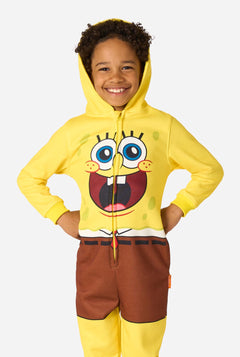 Child wearing a yellow SpongeBob onesie with a white background