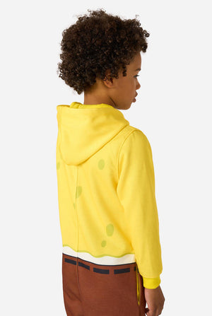 Child wearing a yellow SpongeBob onesie with a white background, image from the side.