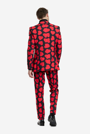 Person wearing a red and black heart-patterned suit on a white background, view from the back