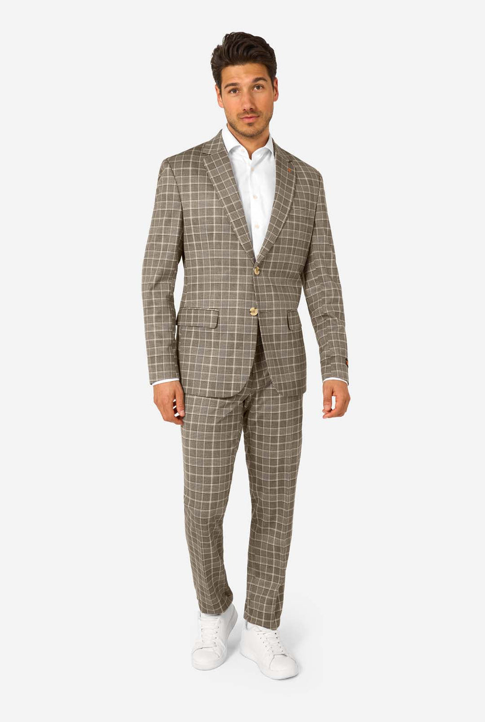 A men wearing a tan checkered suit with a white dress shirt. The suit has a modern fit with two buttons and flap pockets. He stands against a plain white background.