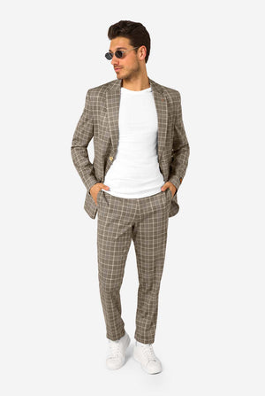 A men wearing a tan checkered suit with a white dress shirt. The suit has a modern fit with two buttons and flap pockets. He stands against a plain white background. Full body image