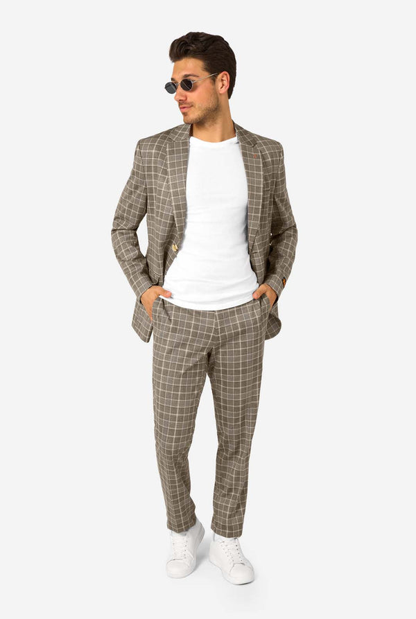 A men wearing a tan checkered suit with a white dress shirt. The suit has a modern fit with two buttons and flap pockets. He stands against a plain white background. Full body image