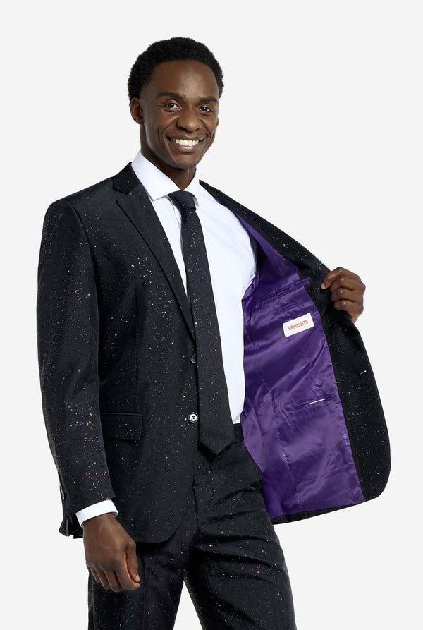 Image of a man wearing an OppoSuits Glitzy Glitter men's suit with glitters and white men's shirt. Suit consist of pants, jacket and tie. Holding one side of the jacket open.