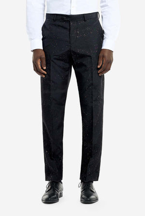 Image of a man wearing an OppoSuits Glitzy Glitter men's suit with glitters and white men's shirt. Suit consist of pants, jacket and tie. Pants view.