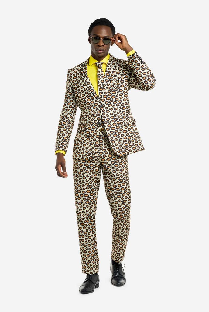 Image of a man wearing an OppoSuits The jag men's suit with panther print and yellow men's shirt. Suit consist of pants, jacket and tie. Also wearing sunglasses.