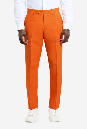 Orange dress pants worn with a white shirt and white shoes on a white background