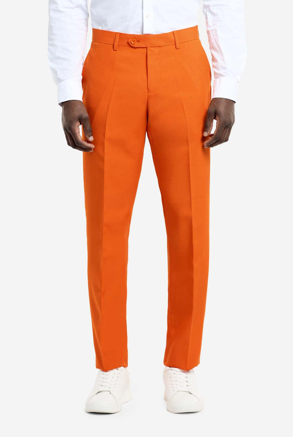 Orange dress pants worn with a white shirt and white shoes on a white background