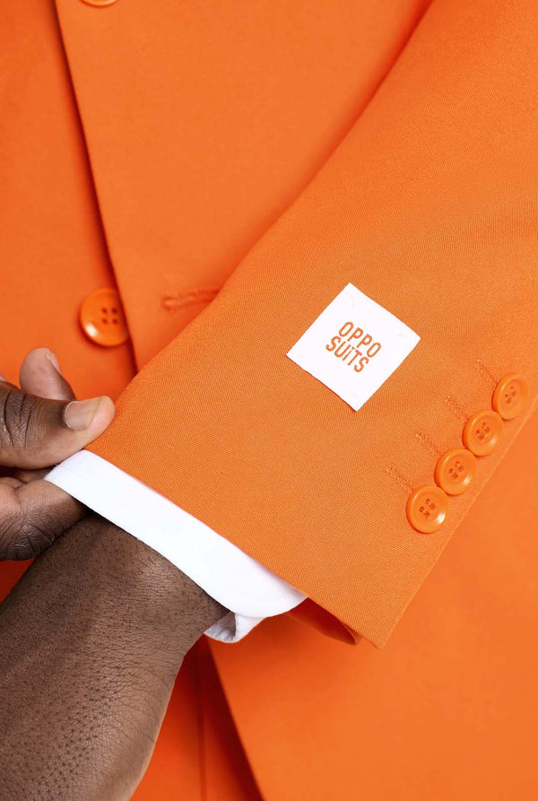 Orange suit with a brand label held by a hand