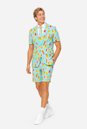 Man wearing light blue summer suit with ice cream and ice loly print. Suits consists of shorts, short sleeved blazer and tie. Full body image.