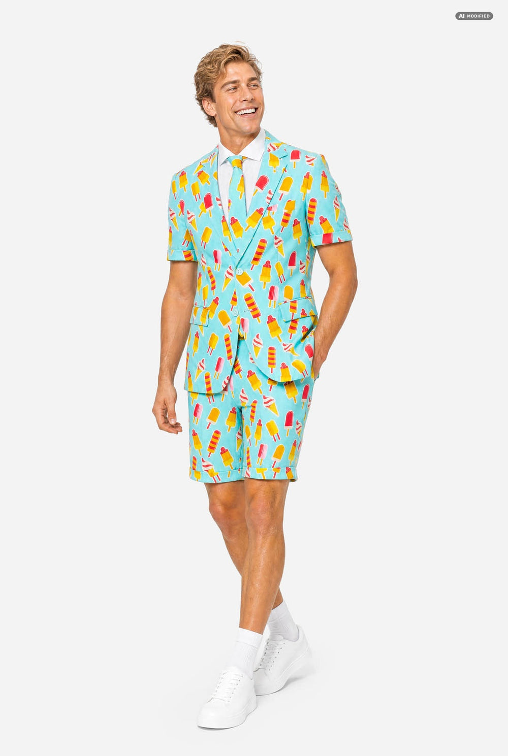 A man modeling a light blue three-piece suit with a colorful ice cream cone pattern, featuring a short-sleeve blazer, matching trousers, and a matching tie, set against a plain light gray background.