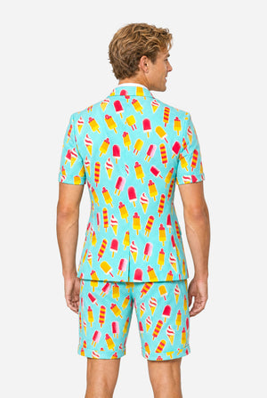 Man wearing light blue summer suit with ice cream and ice loly print. Suits consists of shorts, short sleeved blazer and tie. View from the back.