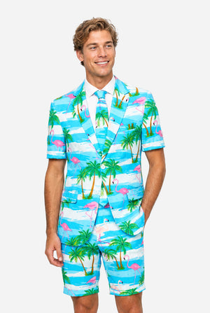 Man wearing a colorful tropical-themed suit, with palm trees and pink flamingos on a light background.