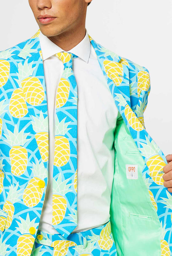 Man wearing blue summer suit with pineapple print. Chest close up.