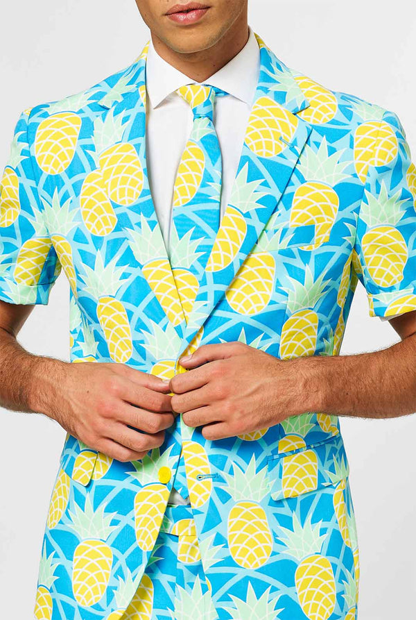 Man wearing blue summer suit with pineapple print. Chest close-up.