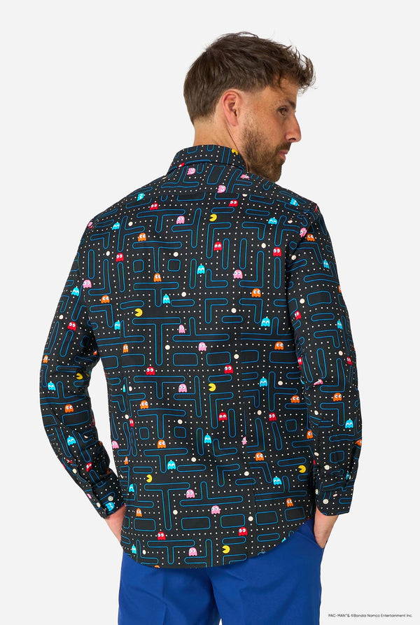Image of a man wearing a black shirt with Pac-Man print and a blue pants. View from the back.