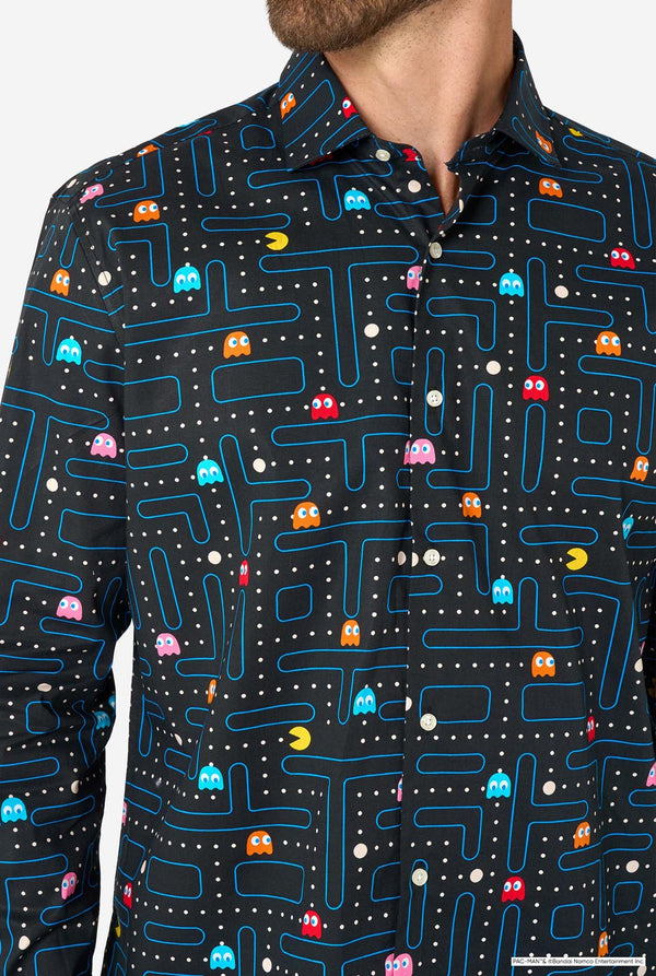 Image of a man wearing a black shirt with Pac-Man print and a blue pants. Chest close-up.