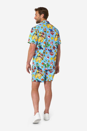 Man wearing a colorful Mario-themed shirt and shorts set on a light background. View from the back.