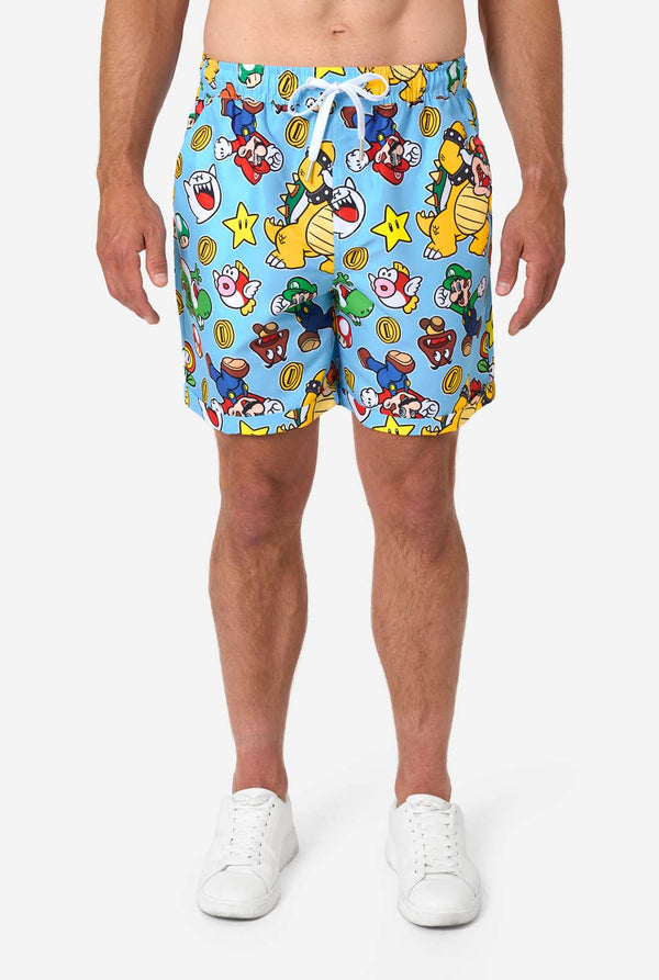 Man wearing a colorful Mario-themed shirt and shorts set on a light background. Shorts close up.