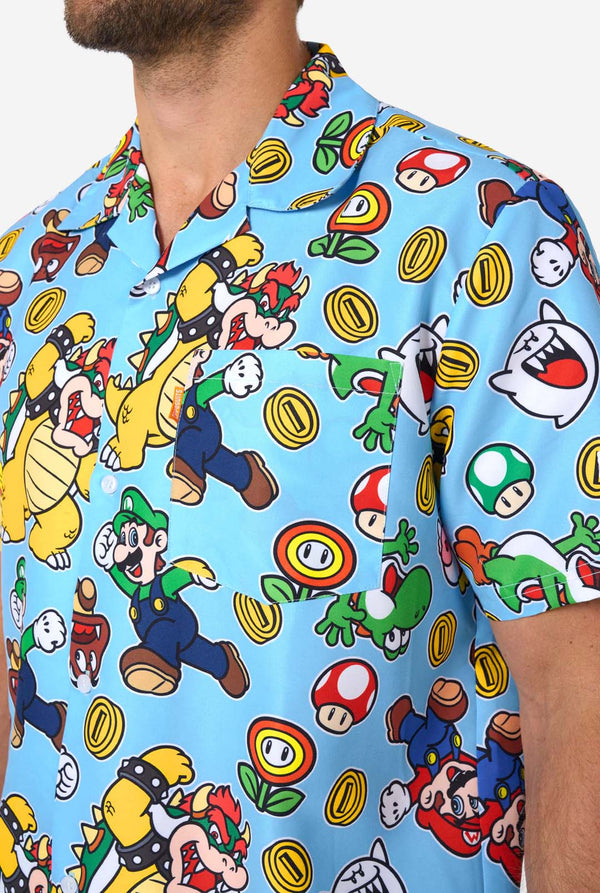Man wearing a colorful Mario-themed shirt and shorts set on a light background. Chest close up.