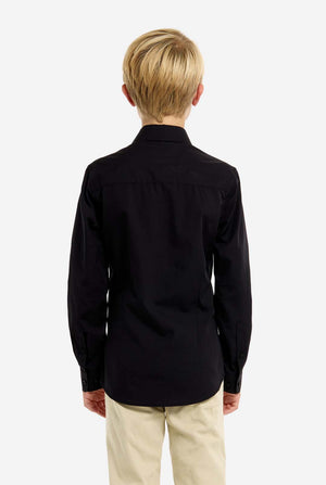 Person wearing a black shirt and beige pants on a white background, view from the back.
