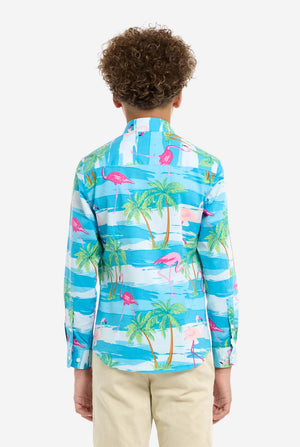 Child wearing a colorful shirt with palm tree and flamingo pattern on a white background, view from the back