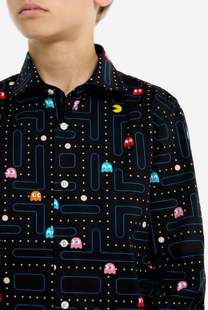Person wearing a black shirt with colorful Pac-Man game pattern, close up